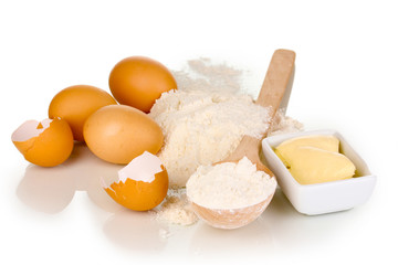 Eggs, flour and butter isolated on white