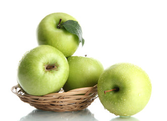 Ripe green apples with leaves in basket isolated on white