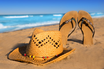 golden sand beach with summer hat and sandals