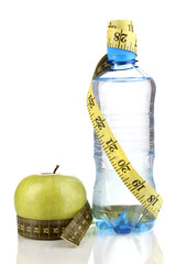 Bottle of water, apple and measuring tape isolated on white