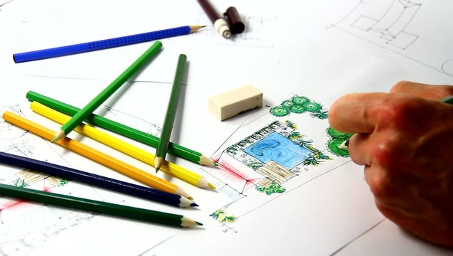 Man sketching architectural landscape drawing.