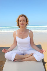Fototapeta na wymiar Woman meditating on the beach
