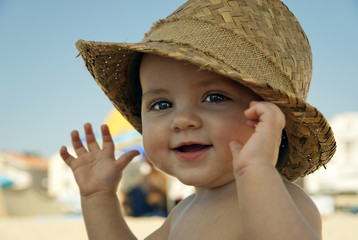 Baby with hat on the beach