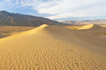 desert sand dunes with mountain in the background