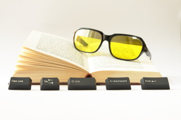 An Open Book, Computer Keys and Sunglasses