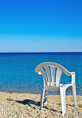 plastic beach chair on shore near sea