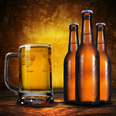 3 beer bottles and a jug of beer on grunge background
