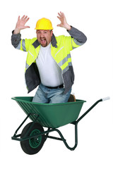 Laborer sitting in a wheelbarrow screaming