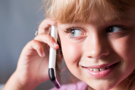 Little blond beautiful girl with mobile phone