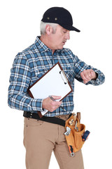A handyman looking at his watch.