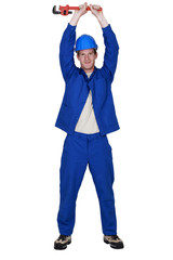 Young plumber raising wrench into the air