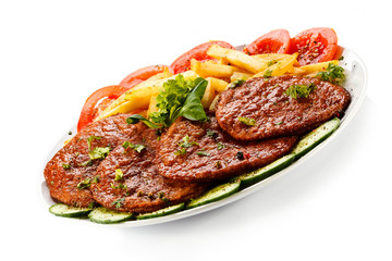 Grilled steaks, French fries and vegetables