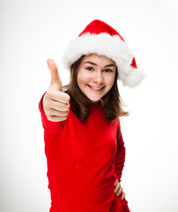 Girl showing OK sign wearing Santa Claus hat