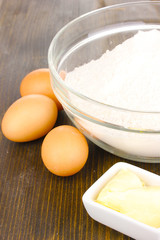 Eggs, flour and butter close-up on wooden table