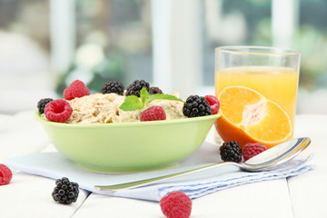 tasty oatmeal with berries and glass of juice