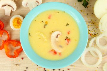 Fragrant soup in blue bowl with ingredients around