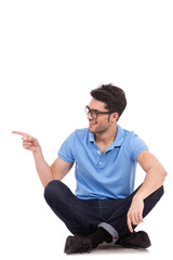 young man sitting and pointing sideways