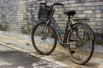 Fototapeta na wymiar Stary zardzewiały rower o ścianę