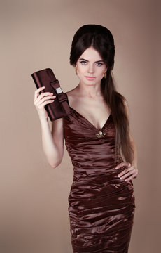 Elegant fashion brunette woman in dress with handbag