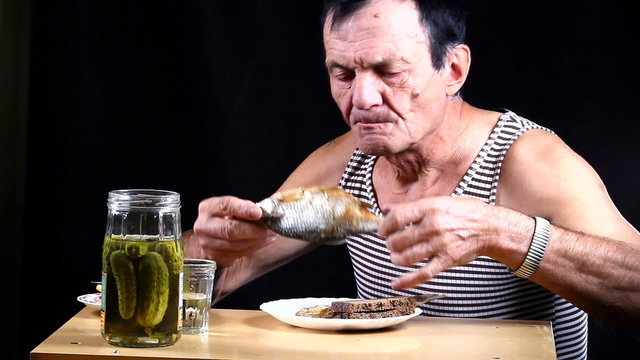 Man drinks and bites pickle