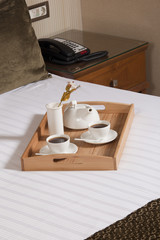 Tray with coffee on a bed in a hotel room 