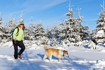 Woman hiking with dog in winter, Poland