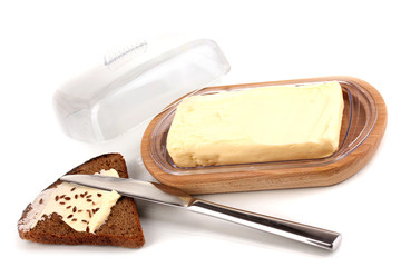 Butter on wooden holder and bread isolated on white