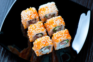 Set of Geisha rolls on a black plate, view from above