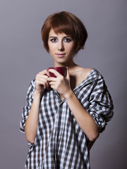 Style girl in shirt with cup at studio.