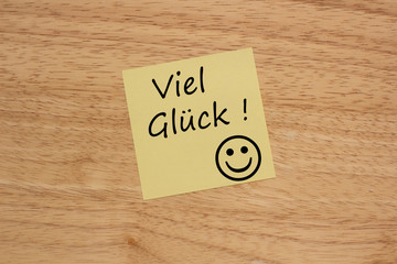 Brett mit einem gelben Zettel und Viel Glück