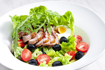 vegetable salad with fried duck breast slices and egg