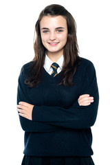 Confident schoolgirl posing with folded arms