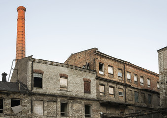 Fototapeta na wymiar Gone industrial building and a chimney