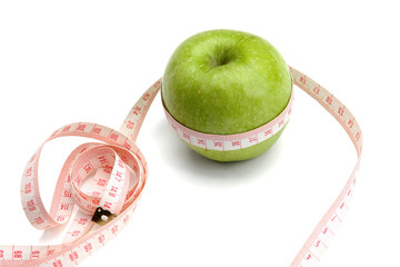 A green apple and a measuring tape