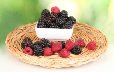 Ripe raspberries and brambles on nature background