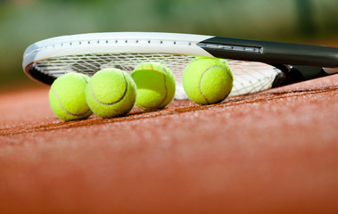 Close up of tennis racquet and balls on the clay tennis court - 45579203