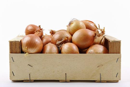 Little wooden crate of onions on white background