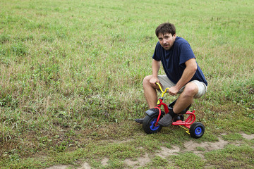 Adult man on a small tricycle