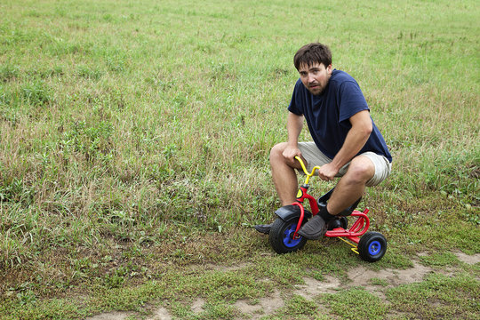 Adult Man On A Small Tricycle