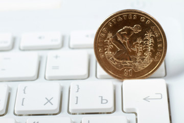 A coin on a laptop keyboard, closeup