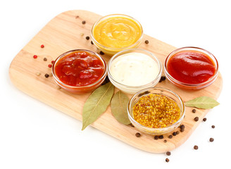 various sauces on chopping board isolated on white