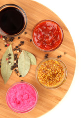various sauces on chopping board isolated on white