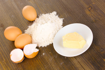 Eggs, flour and butter close-up on wooden table