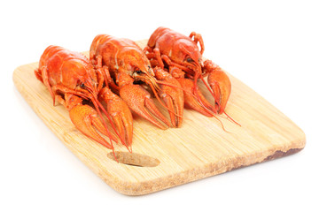 Tasty boiled crayfishes on chopping board isolated on white