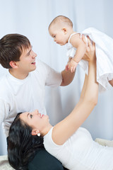 Fototapeta premium Happy family playing with a baby