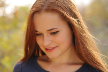 Fototapeta premium Young redhead woman in the park