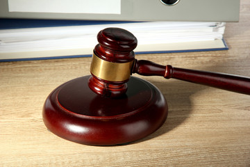 wooden gavel and folders on wooden table, close up