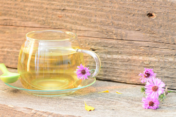Obraz na płótnie Canvas tea cup with different flowers on wood