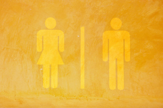 Toilet sign on yellow grunge cement wall