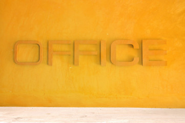 Office text sign on orange grunge cement wall with street